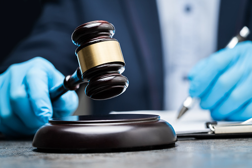 judge-in-gloves-to-protect-from-coronavirus-writing-on-paper